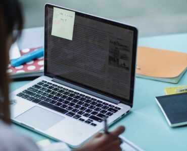 A student reviews application notes beside a laptop.