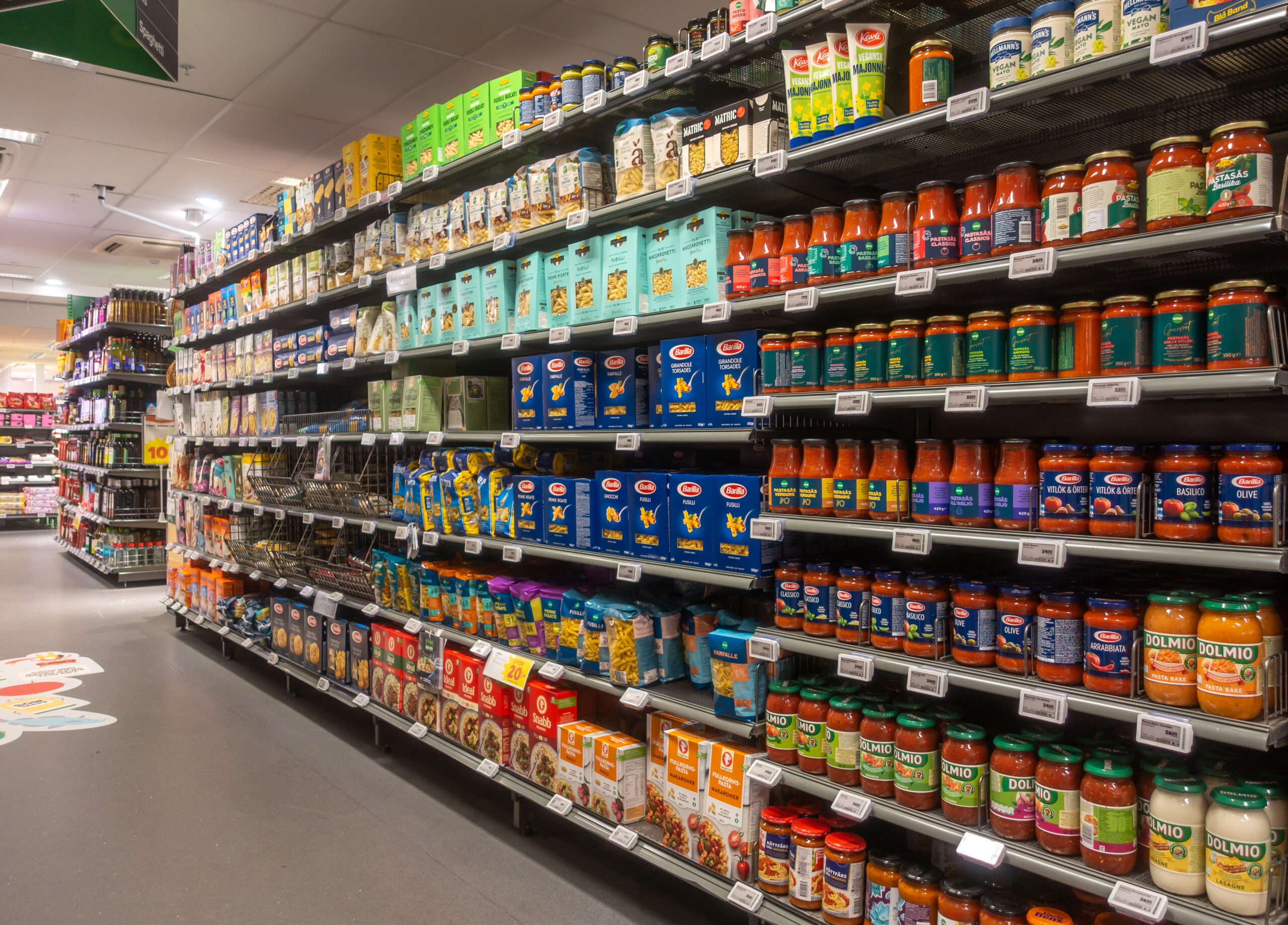 A supermarket aisle with many product choices, representing how shoppers compare value at the margin.