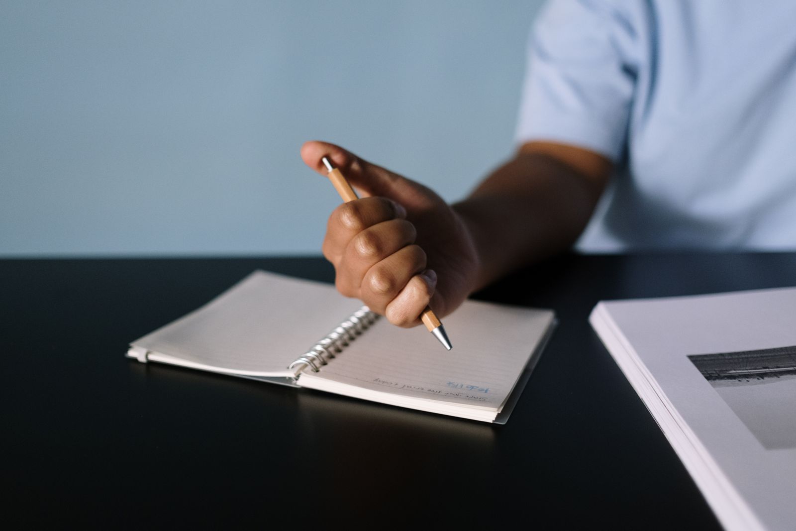 Hand editing a dialogue draft in a notebook with a pen