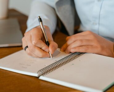 Writer revising dialogue by hand in an open notebook