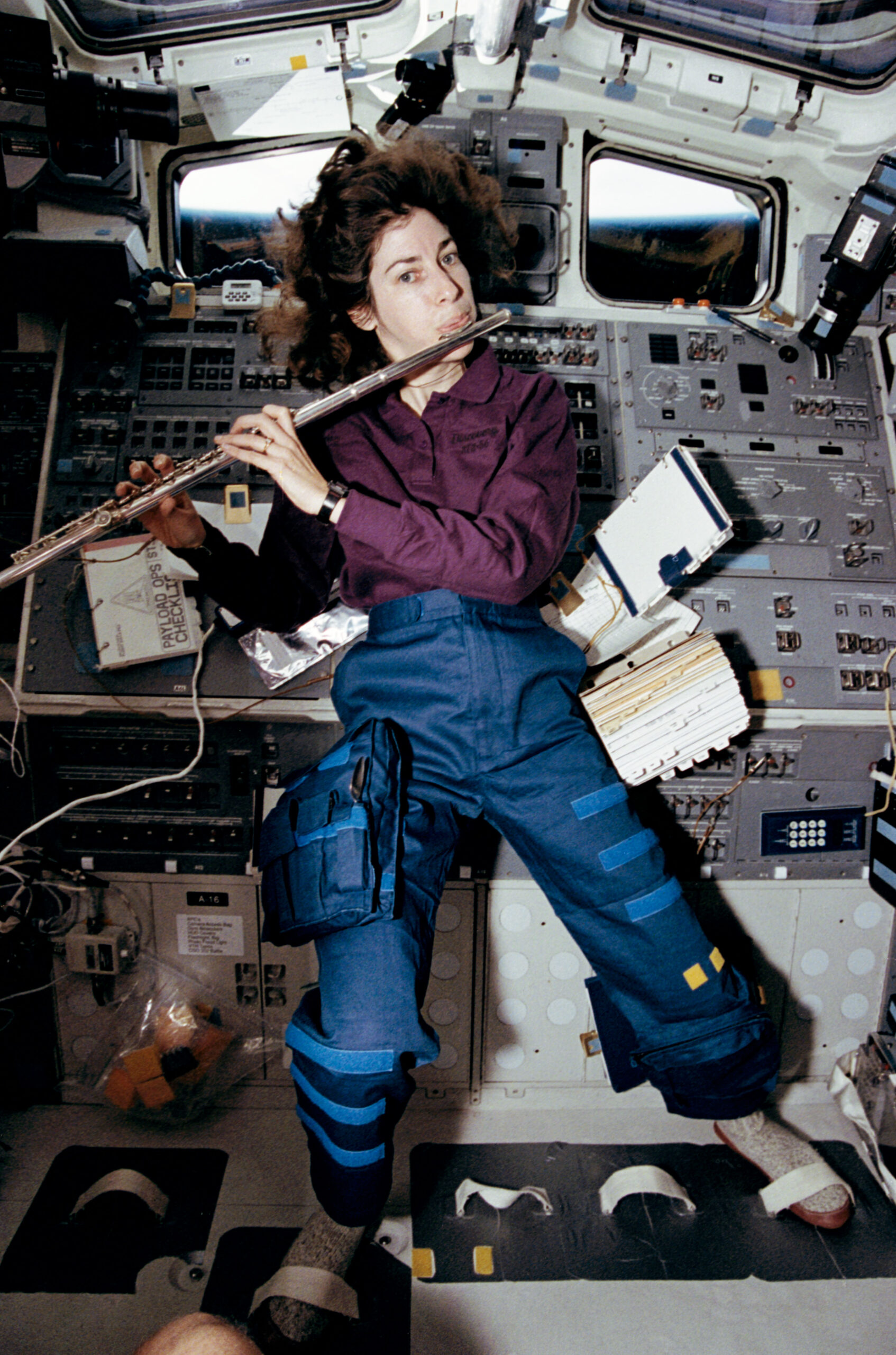 Ellen Ochoa plays a flute in microgravity aboard Space Shuttle Discovery during STS-56.