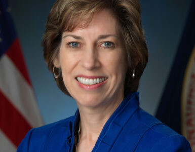 Ellen Ochoa in an official NASA portrait, wearing a blue jacket.