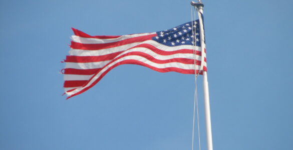An American flag waving above the U.S. Capitol, representing federal budget decisions made by Congress.