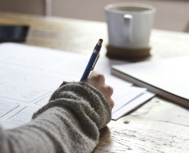 A student organizing notes used to understand the context behind a college application.