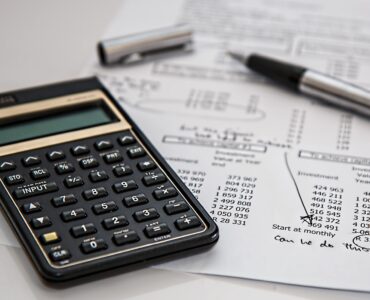 A calculator and payroll paperwork representing the employment data behind the monthly jobs report.