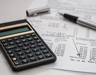 A calculator and payroll paperwork representing the employment data behind the monthly jobs report.