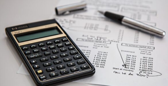 A calculator and payroll paperwork representing the employment data behind the monthly jobs report.