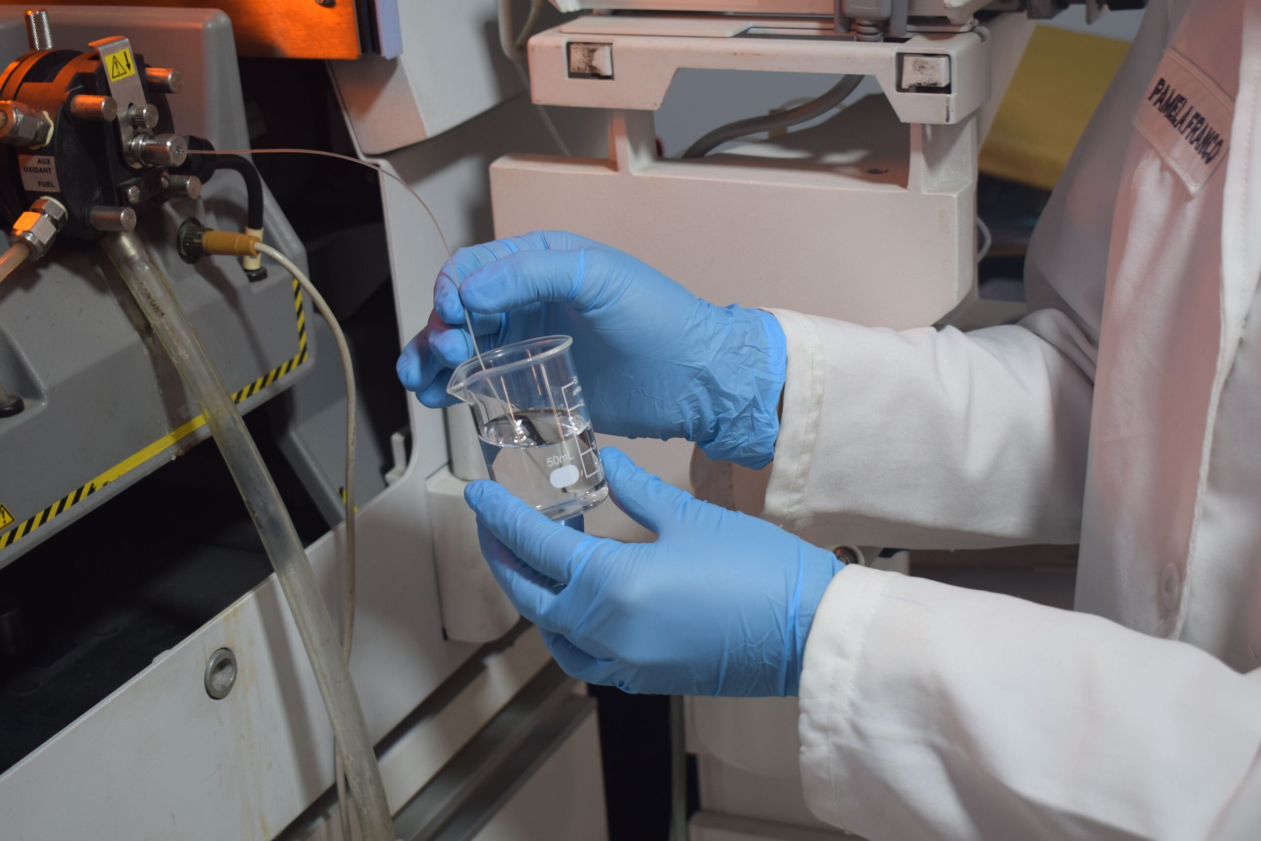 A researcher handling a water sample in a laboratory.