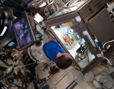 NASA astronaut Megan McArthur working with a life science experiment aboard the International Space Station.