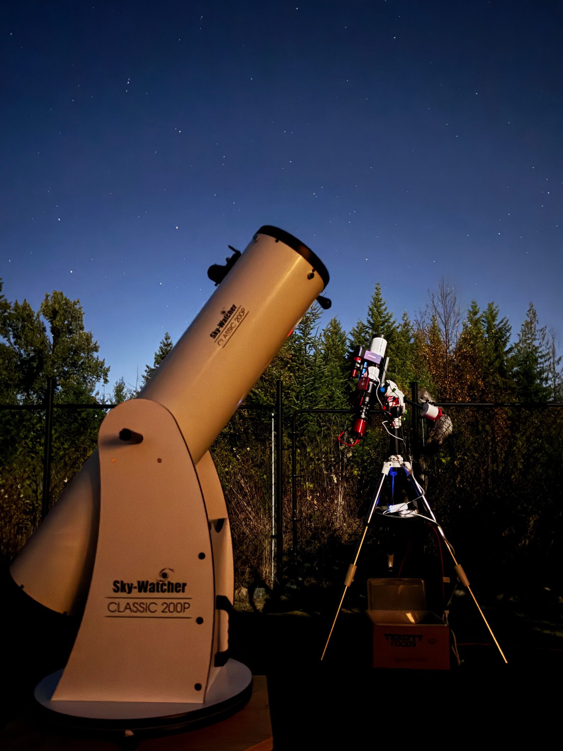 A backyard telescope aimed at a clear night sky for observing a faint outer planet.