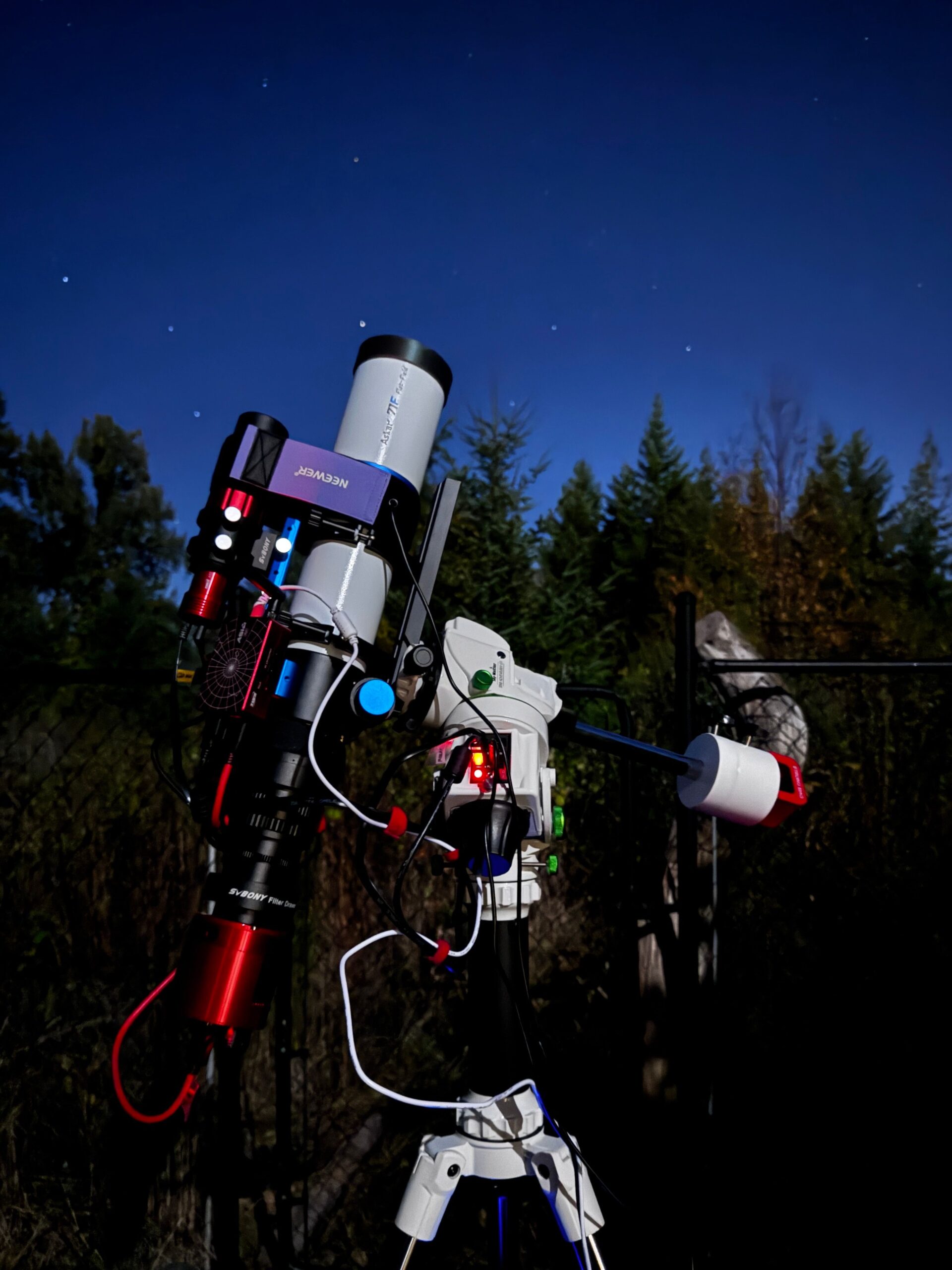 A telescope mount and optical tube set up under a clear night sky for careful planet observation.