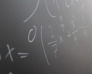 Mathematical equations written in chalk across a classroom blackboard.