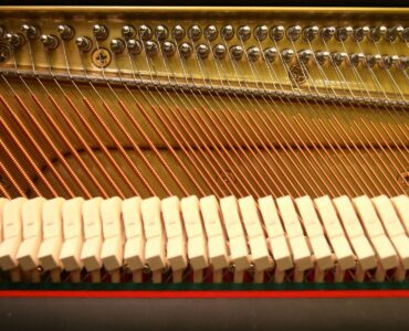 Close view of strings, hammers, and tuning pins inside a piano