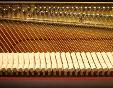 Close view of strings, hammers, and tuning pins inside a piano