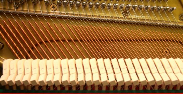 Close view of strings, hammers, and tuning pins inside a piano