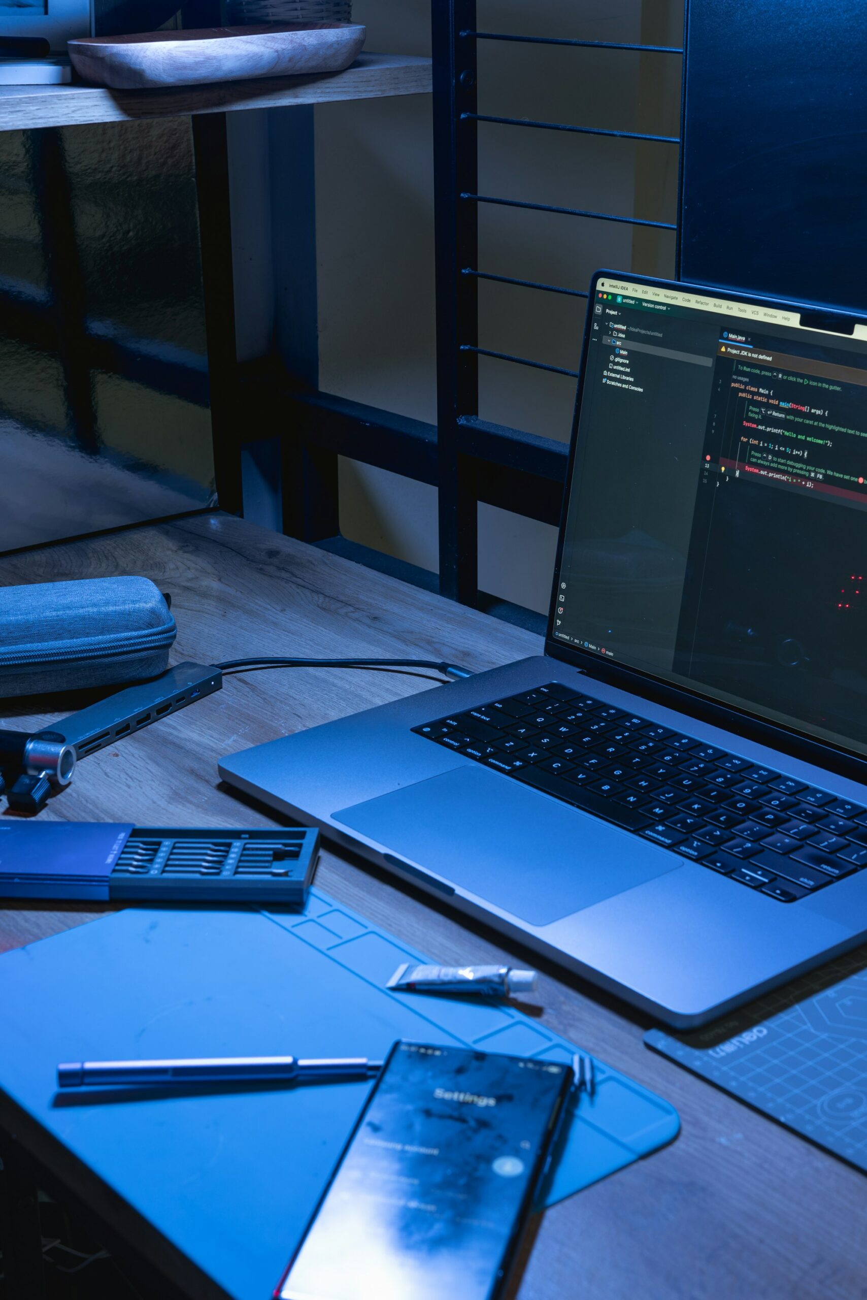 Laptop displaying software code beside a smartphone on a desk