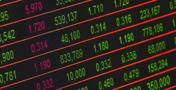 Electronic stock market board displaying changing prices in red and green