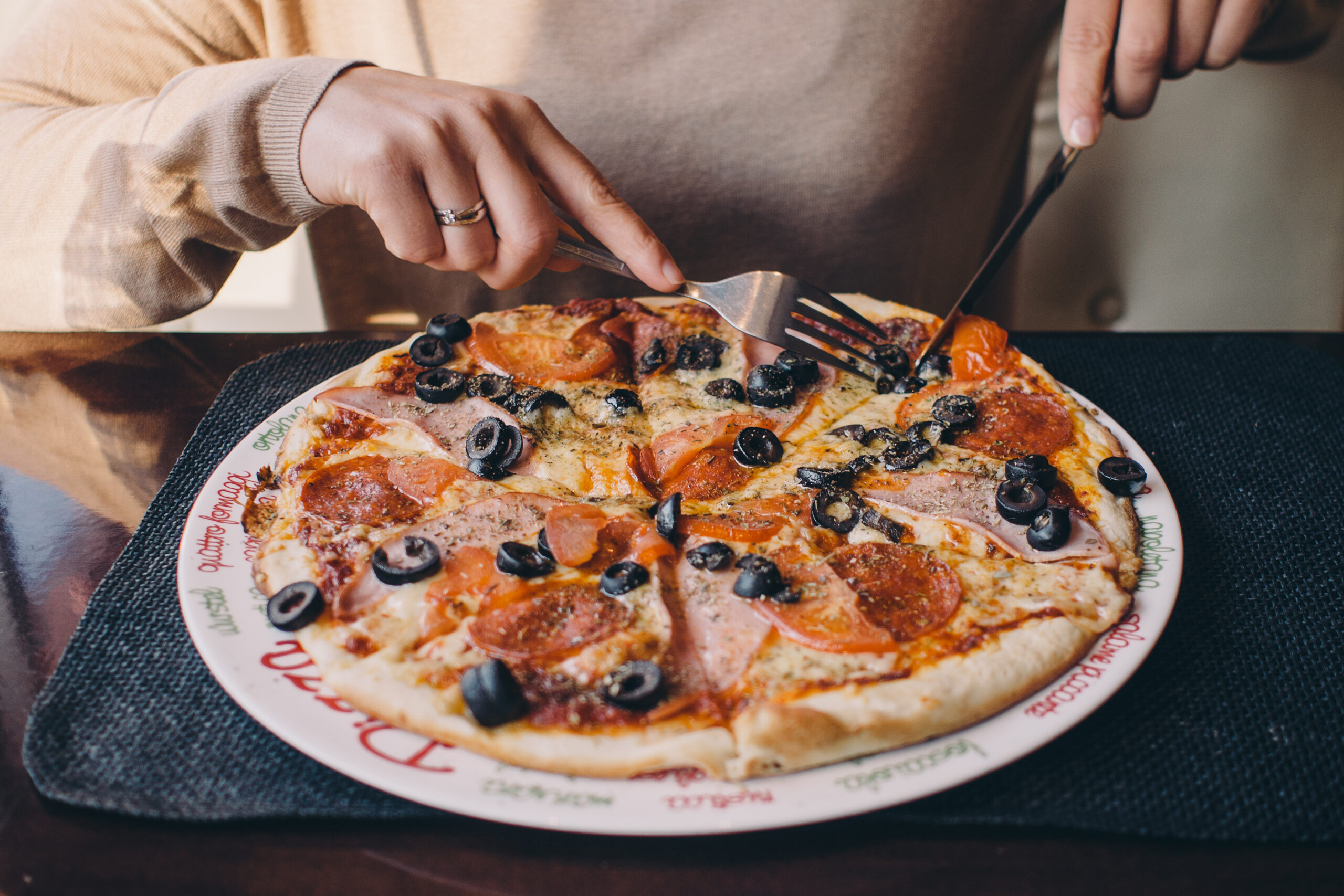 People sharing pizza at a table, showing how satisfaction can change as more servings are eaten.
