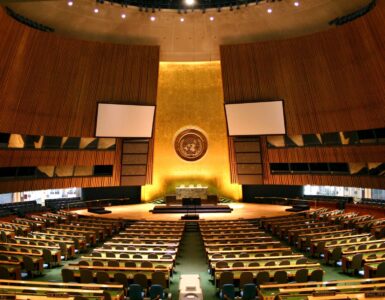 The United Nations General Assembly Hall with rows of delegate desks facing the main rostrum