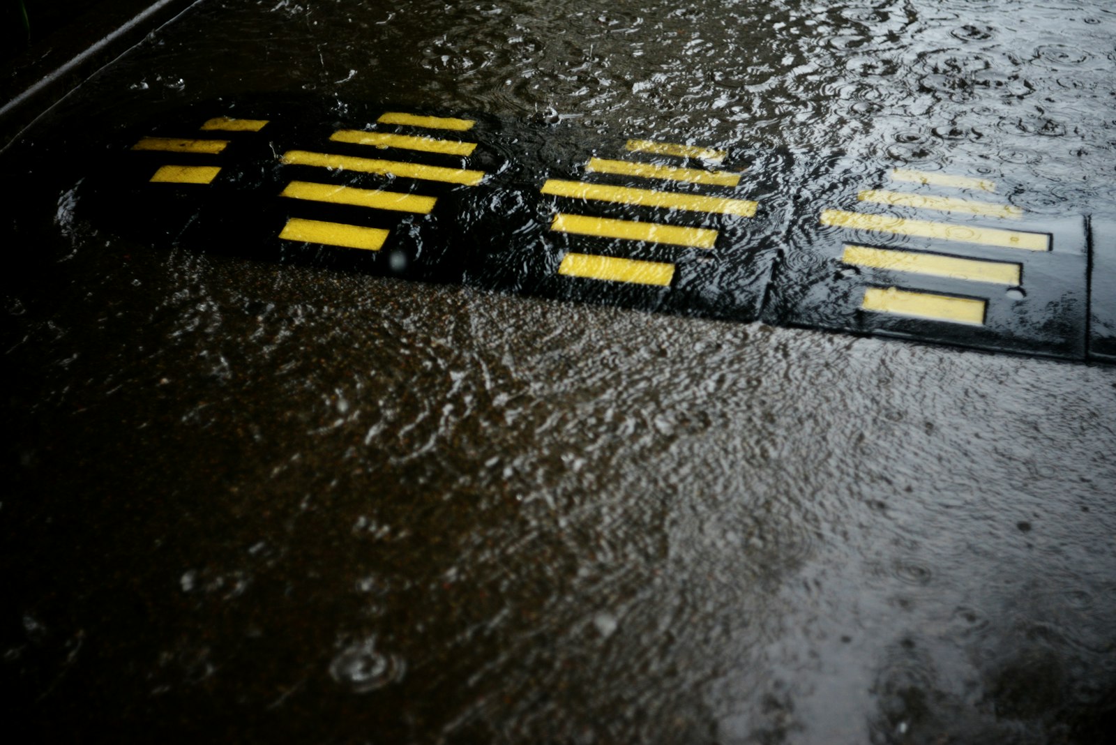 Rainwater flowing toward a city drain, representing the precipitation chances shown in weather apps.