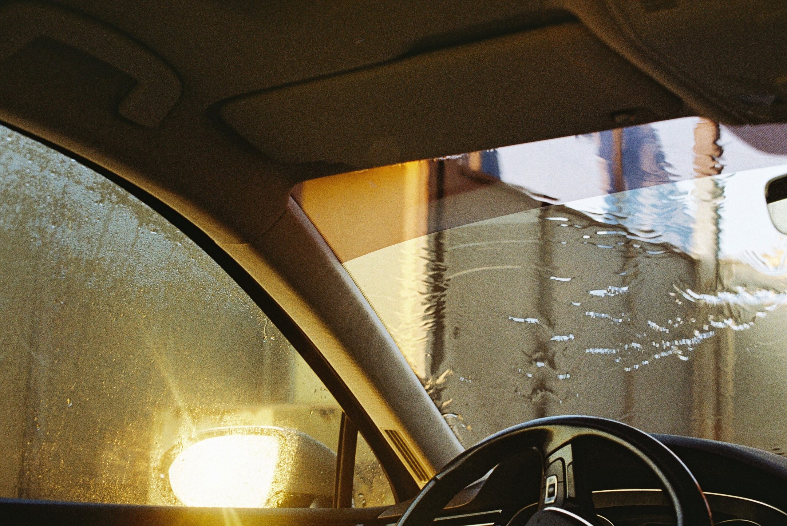 Water droplets on a car windshield seen from the driver's seat