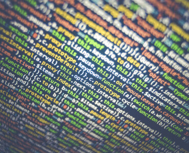Close-up of colorful computer code on a dark screen, suggesting software values and limits.
