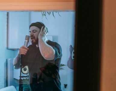 Singer recording beside acoustic wall panels in a professional studio