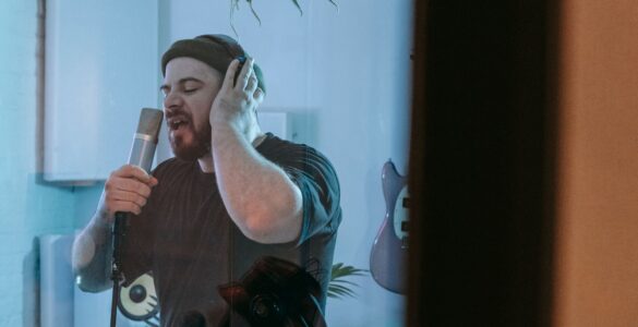 Singer recording beside acoustic wall panels in a professional studio
