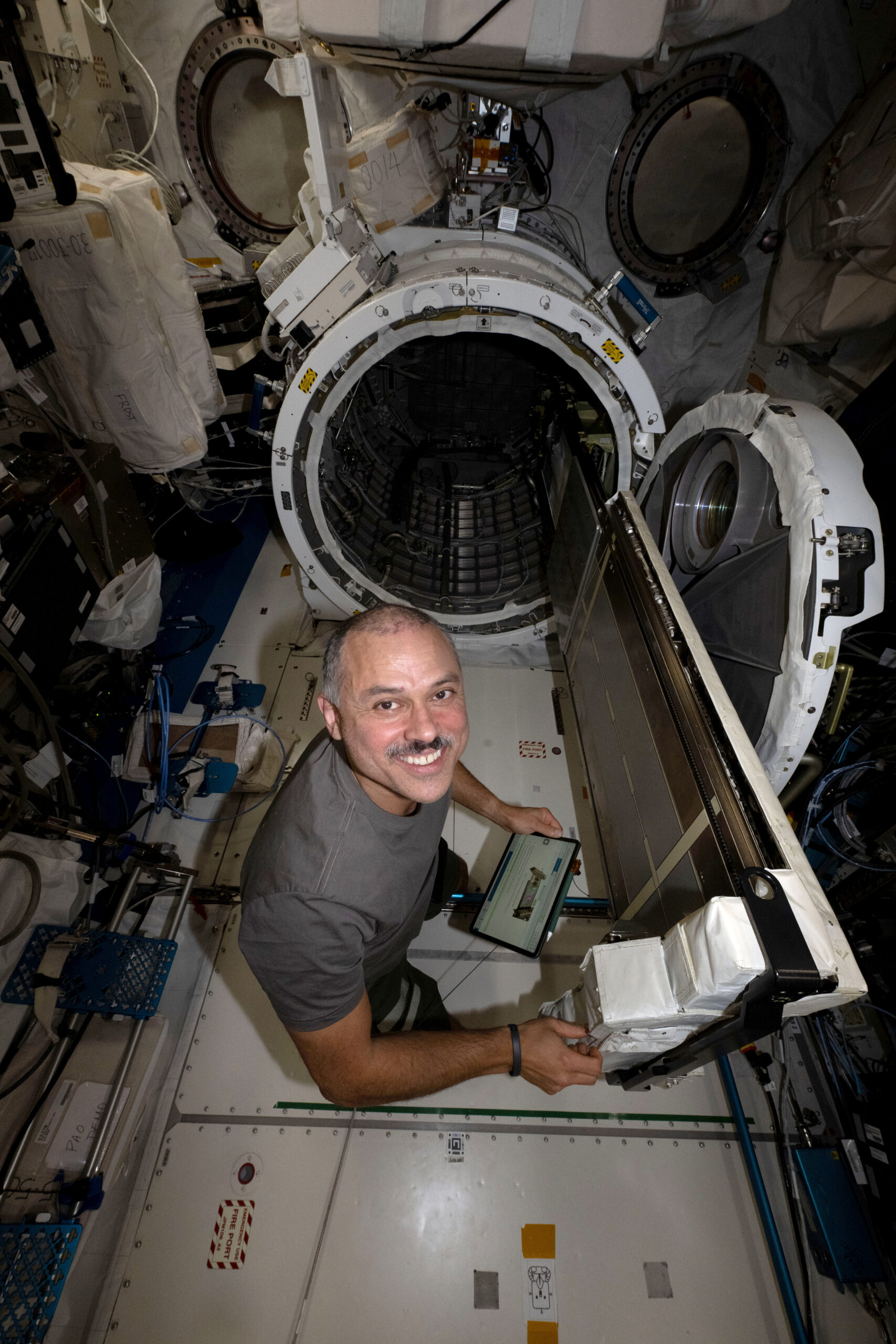 NASA astronaut Anil Menon working among scientific equipment inside the International Space Station's Kibo laboratory