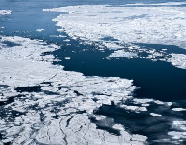 Aerial view of broken sea ice floating across dark polar ocean water