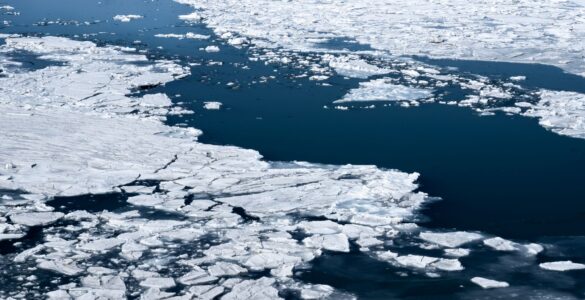 Aerial view of broken sea ice floating across dark polar ocean water
