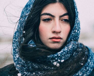 A person wearing a scarf outdoors in snowy winter weather