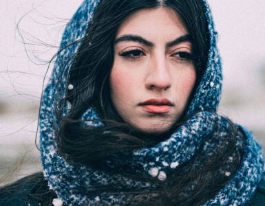 A person wearing a scarf outdoors in snowy winter weather