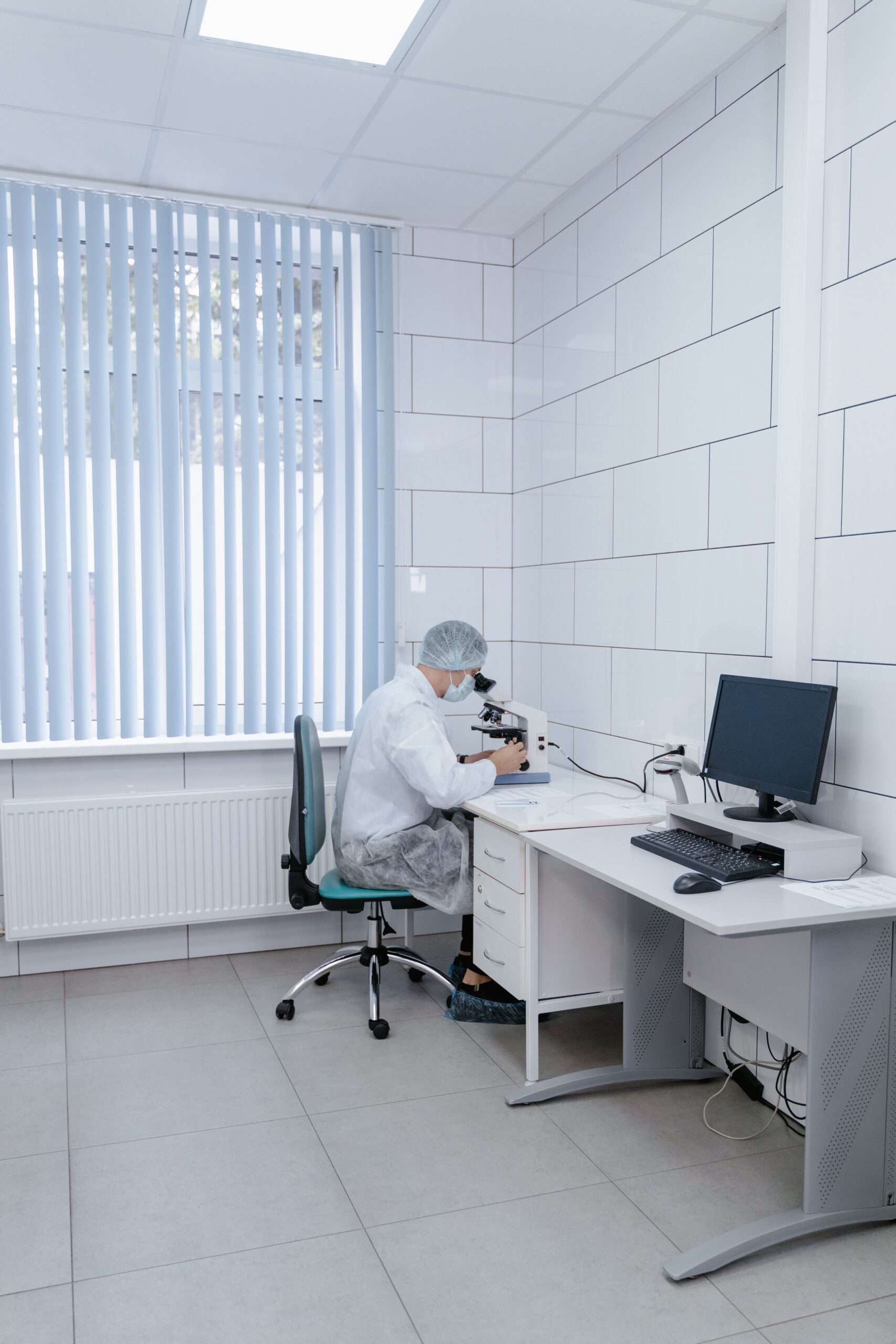 A scientist examining samples through a microscope in a laboratory
