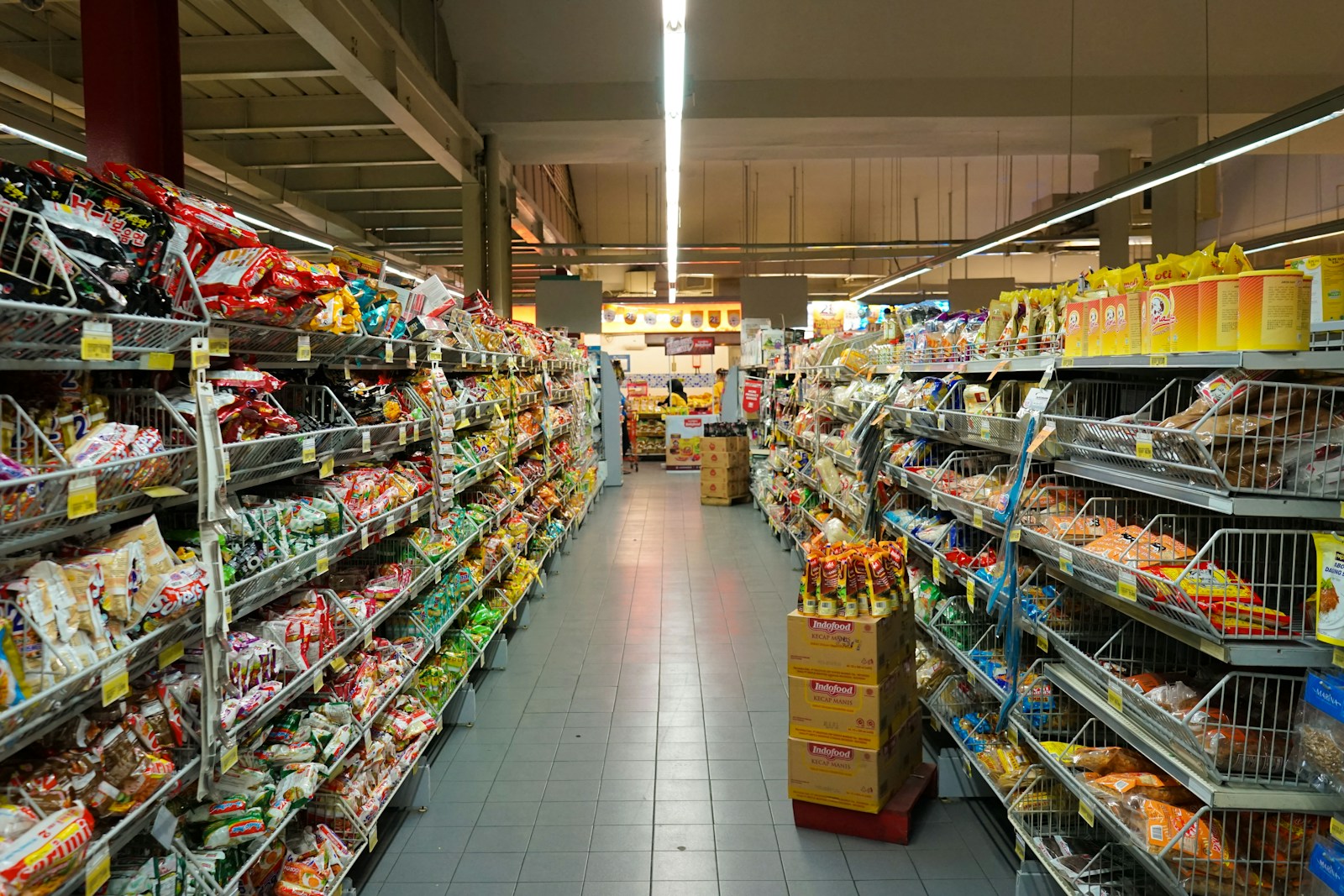 Long supermarket aisle lined with products and price labels