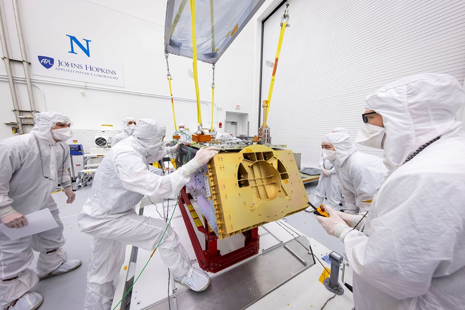 Engineers assembling the top deck of NASA's Dragonfly rotorcraft in a cleanroom