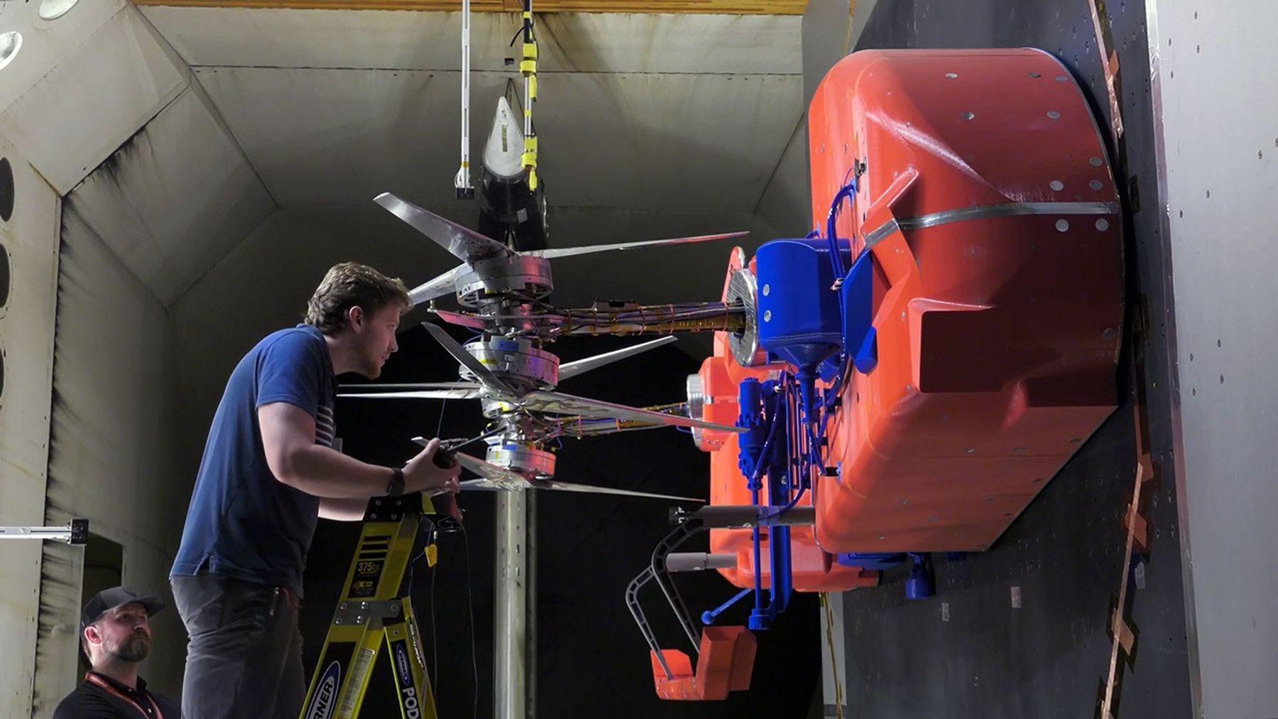 Engineers adjusting Dragonfly rotor blades on a full-scale wind tunnel test model