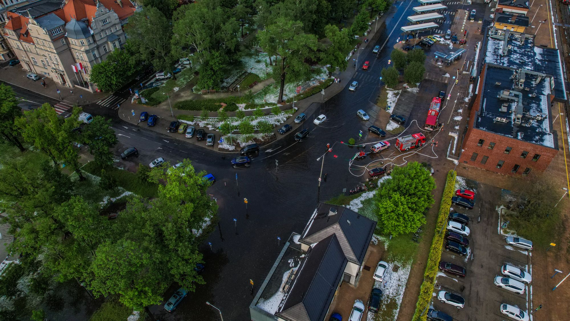 Aerial view of a flooded city intersection with emergency vehicles nearby