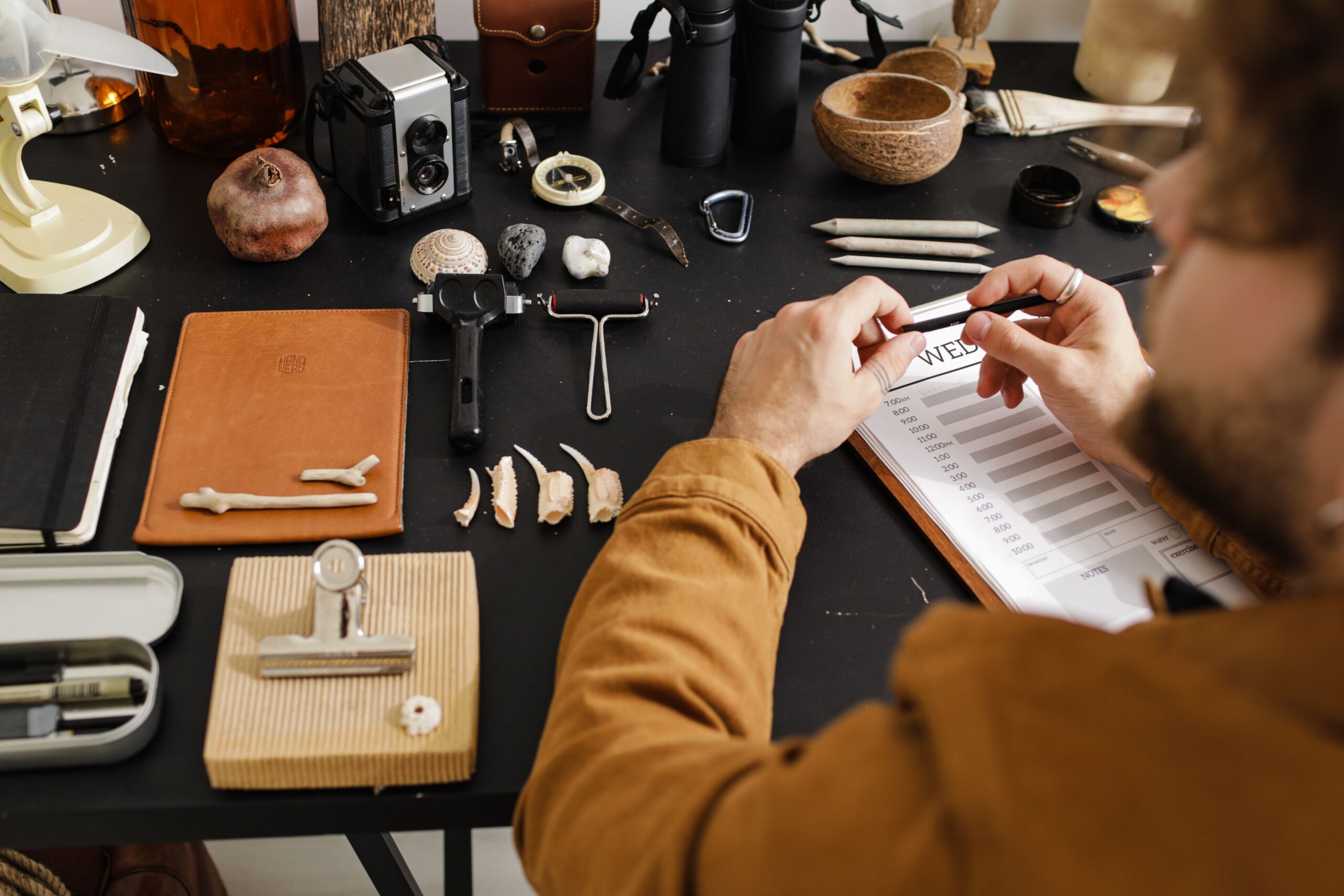 A researcher measuring and documenting fossils on a worktable