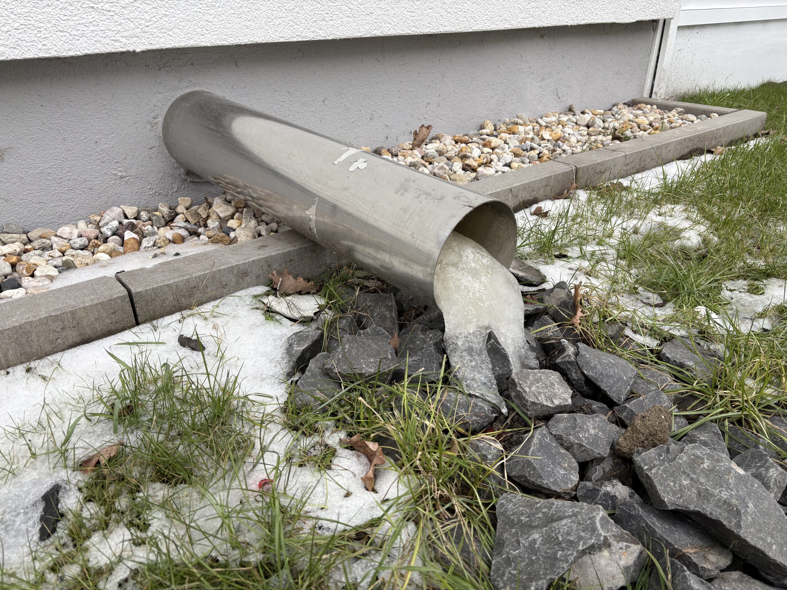 Ice covering an exposed outdoor water pipe during freezing weather