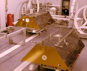 Twin GRACE satellites standing side by side in a clean room before launch