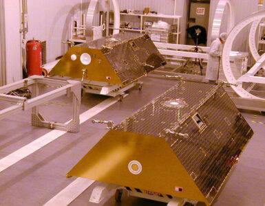 Twin GRACE satellites standing side by side in a clean room before launch