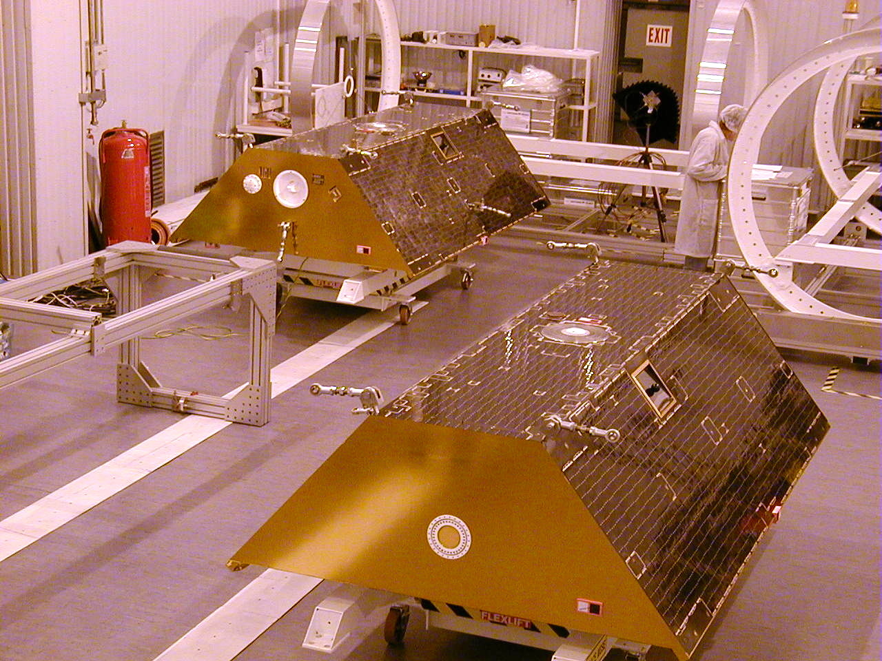 Twin GRACE satellites standing side by side in a clean room before launch