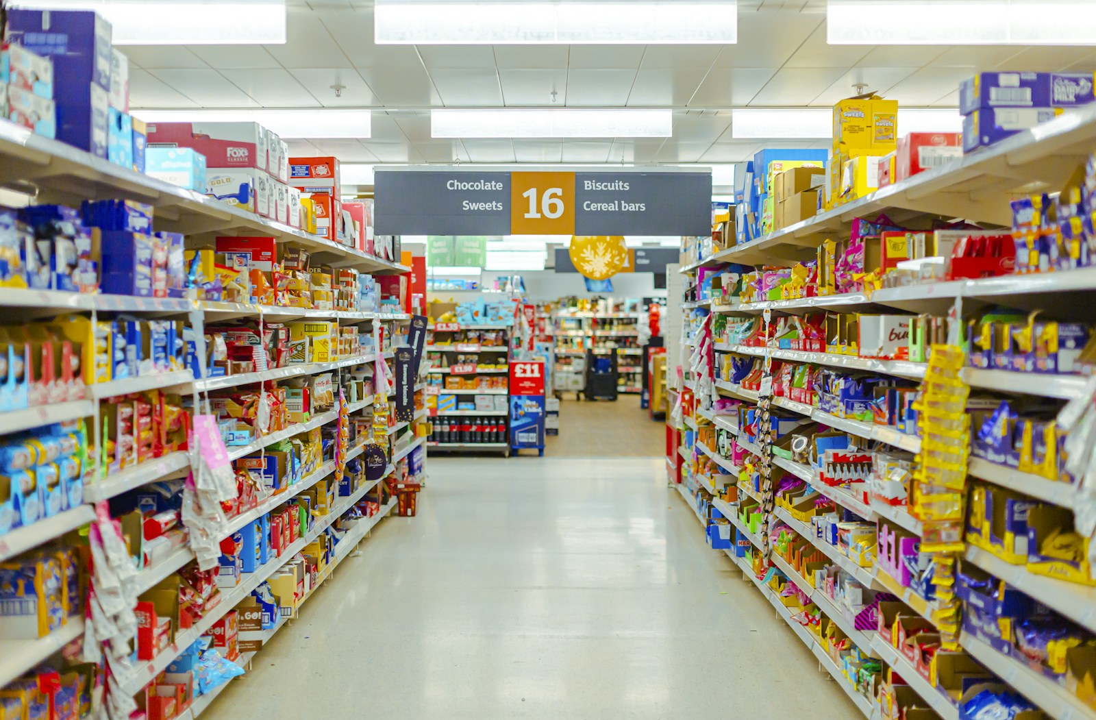 Grocery store shelves filled with packaged products and visible price labels