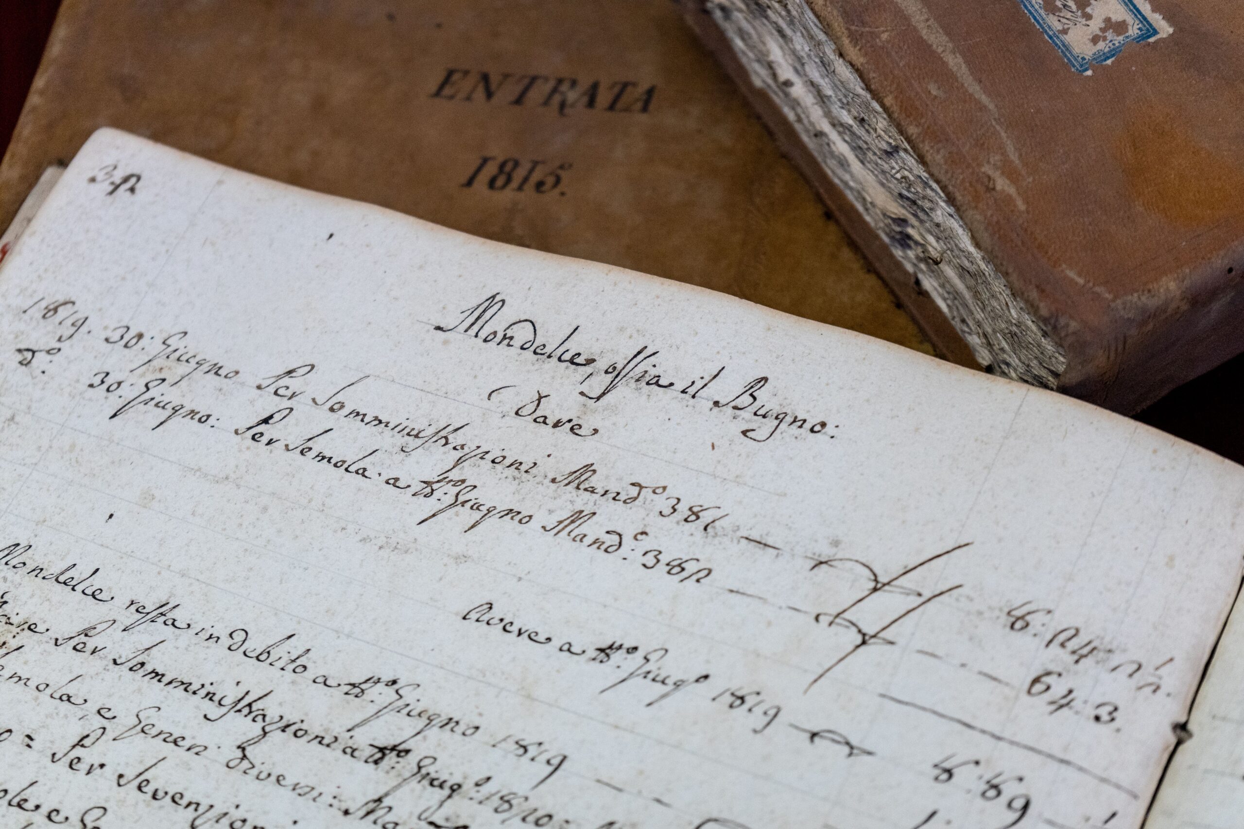 Close view of handwritten manuscript pages and antique books