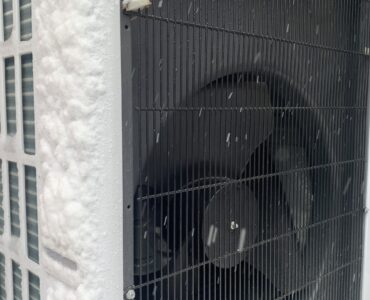 Outdoor air-source heat pump operating beside snow
