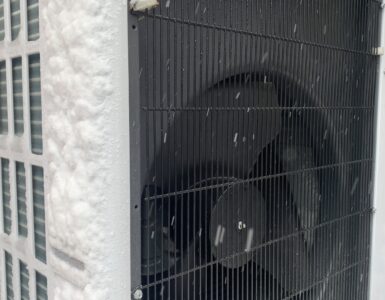 Outdoor air-source heat pump operating beside snow