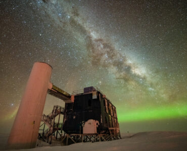 The IceCube Laboratory beneath a star-filled Antarctic sky at the South Pole.