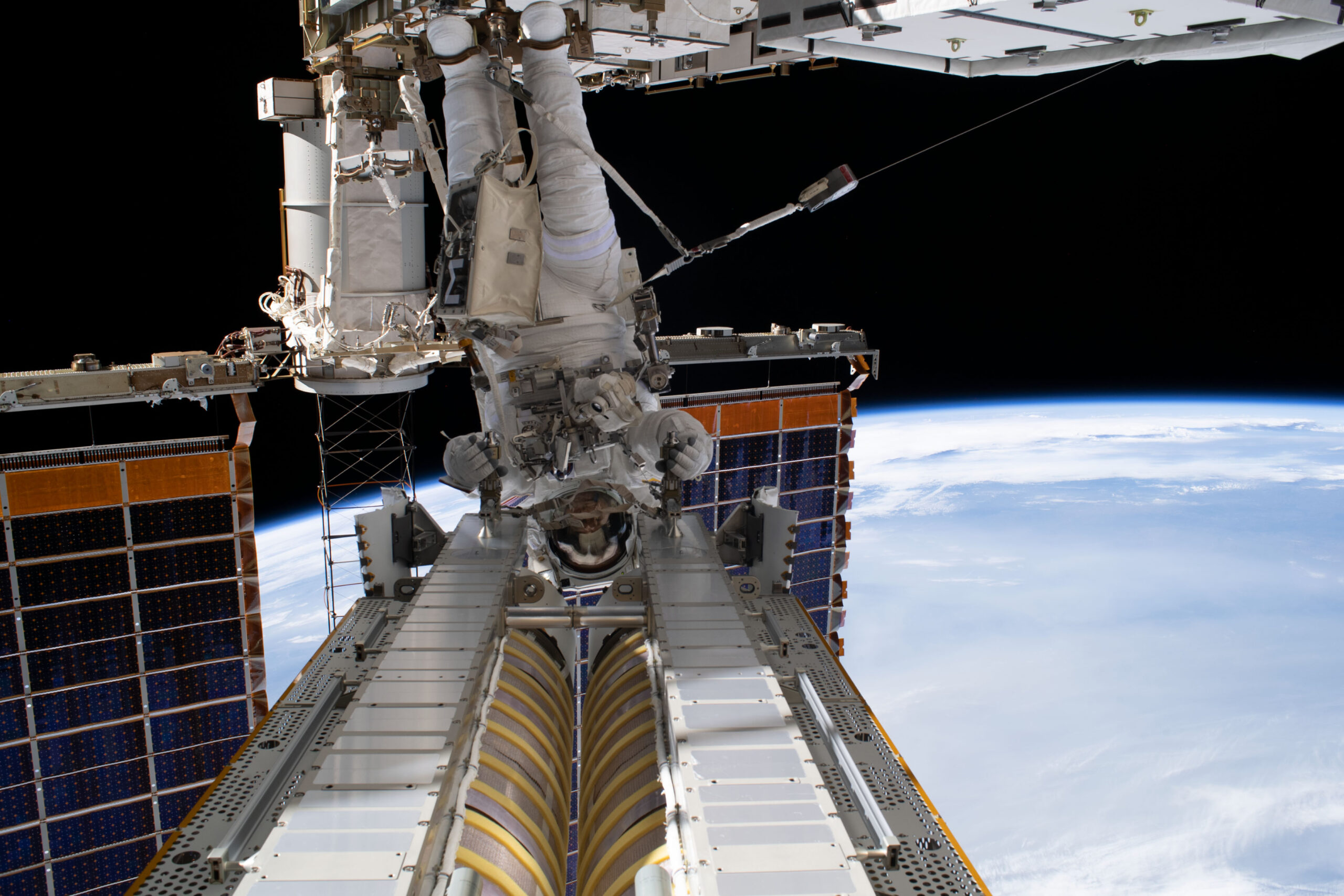 Astronaut Stephen Bowen works beside a roll-out solar array during a spacewalk outside the International Space Station