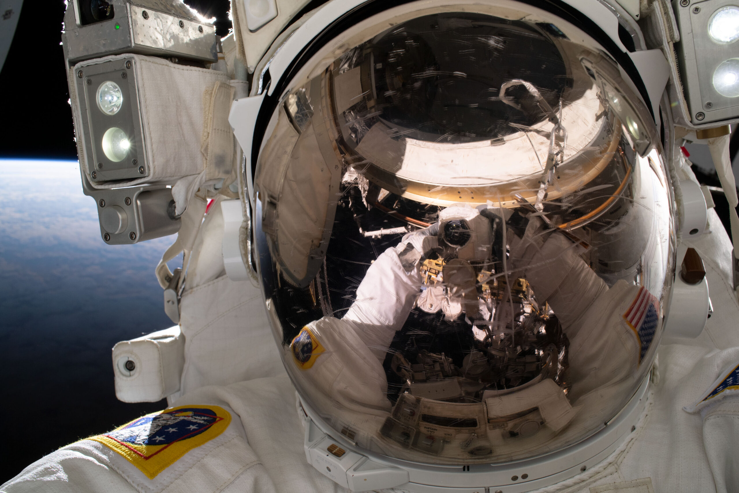 Astronaut works among the truss and solar array hardware outside the International Space Station
